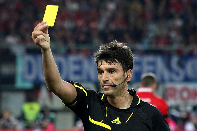 referee giving out a yellow card booking